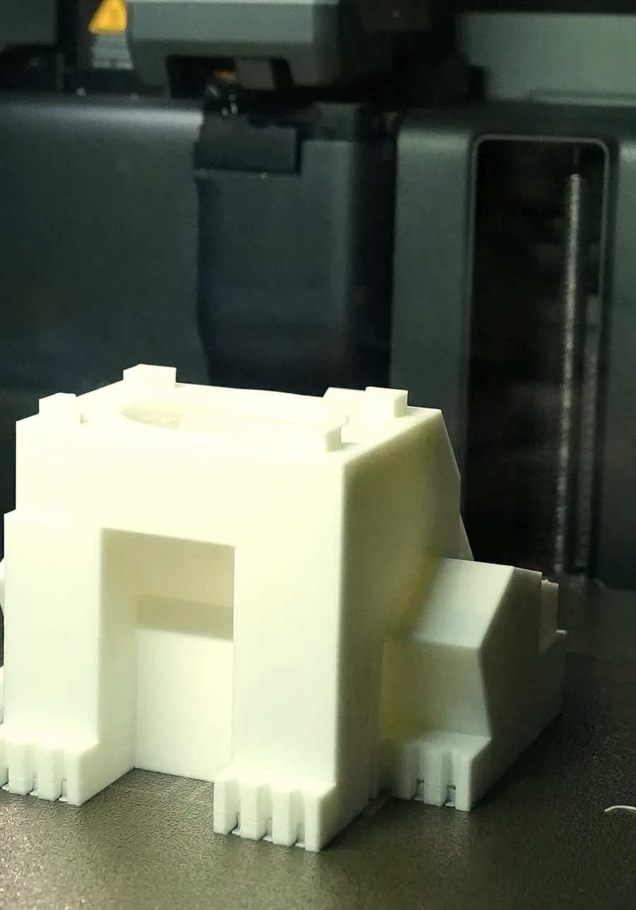 A blocky low detail piggy bank on a printer bed, its body built from large flat panels meeting at hard corners